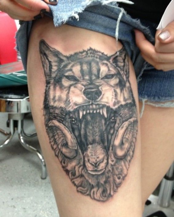 głowa wilka tatuaż na udzie