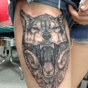 głowa wilka tatuaż na udzie